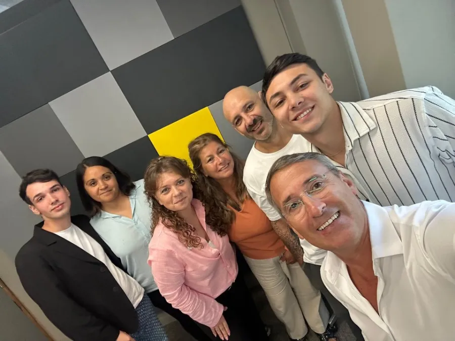 El equipo frente a la pared de cuadros gris, negro y amarillo